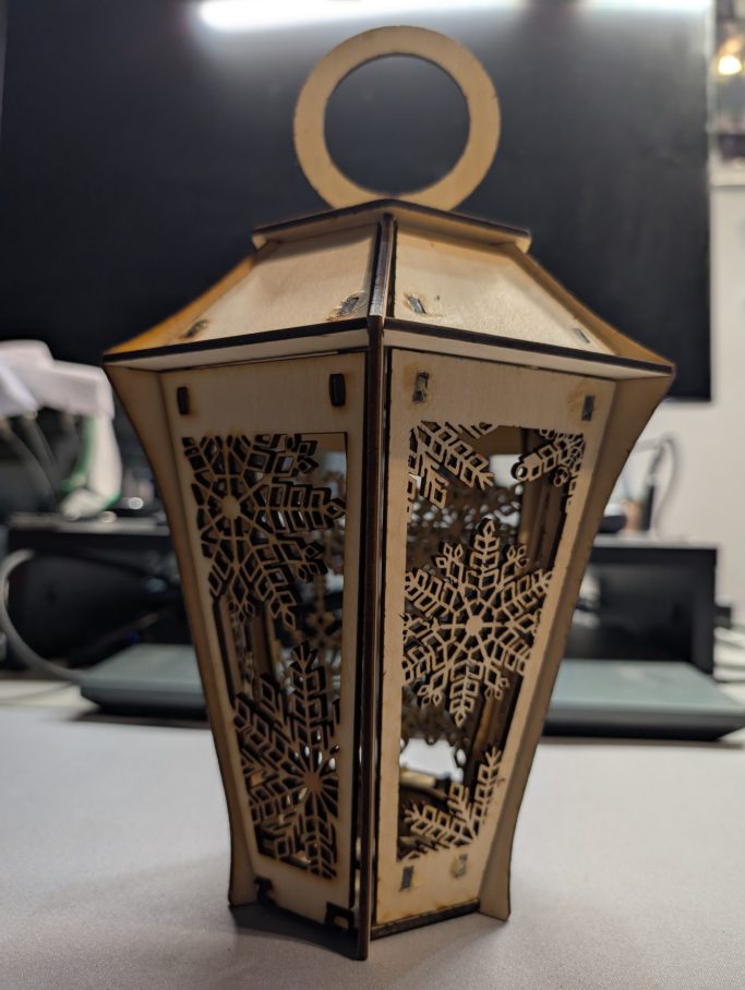 Laterne mit filigranen Mustern und einem runden Henkel oben.